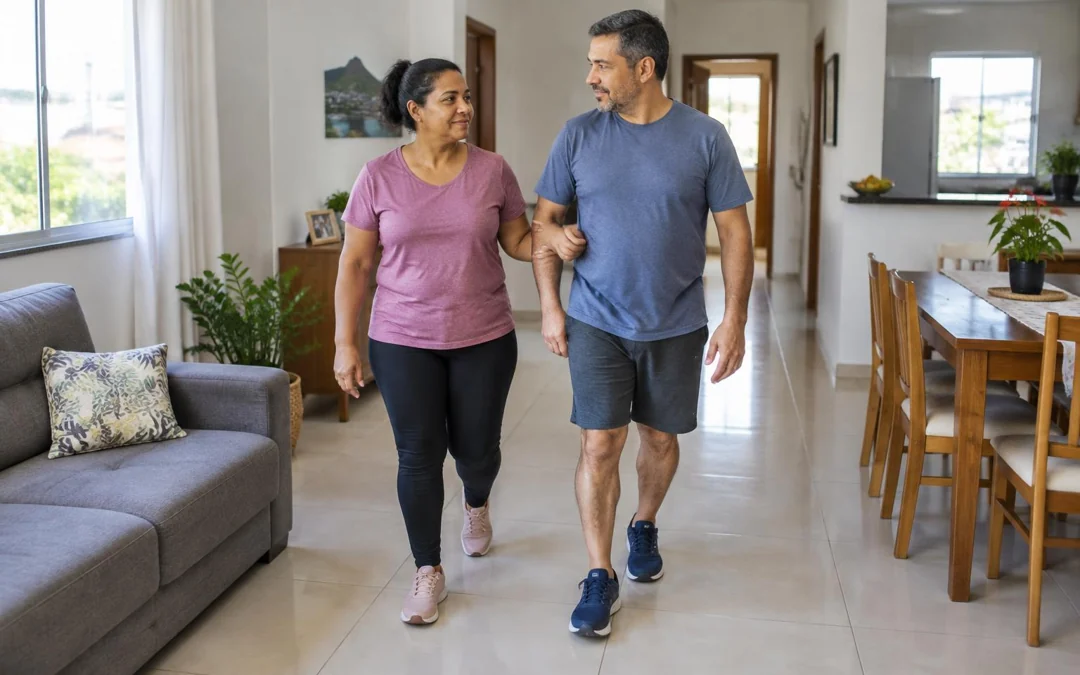 Mulher caminhando em casa apoiada de leve no braço do marido.